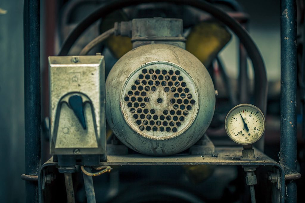 Run-down, old air compressor which needs repair and maintenance.